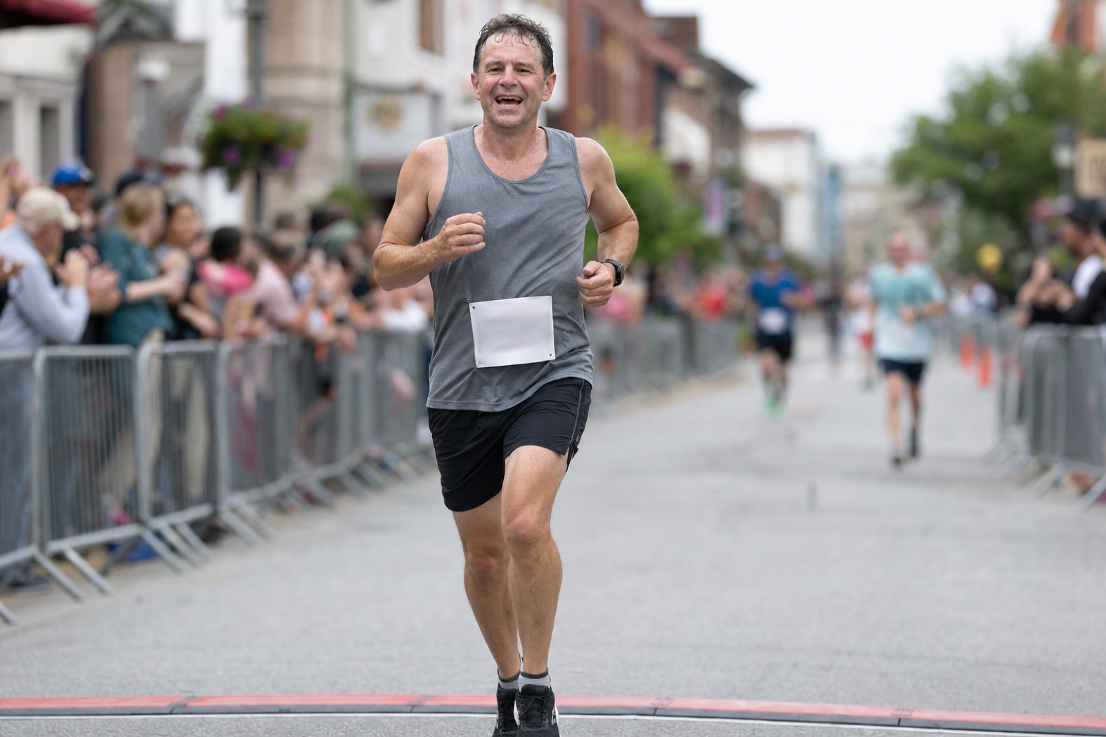 A runner crossing the finish line of a local road race